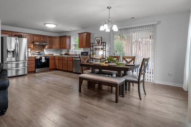 dining room featuring a chandelier, sink, and wood-type flooring