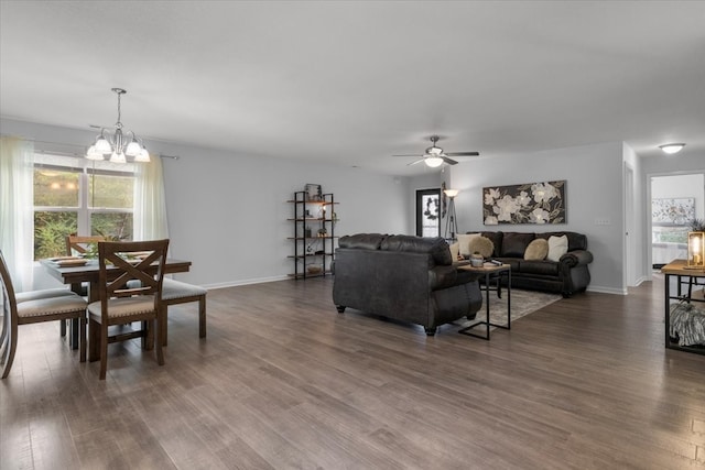 living room featuring dark hardwood / wood-style flooring and ceiling fan with notable chandelier