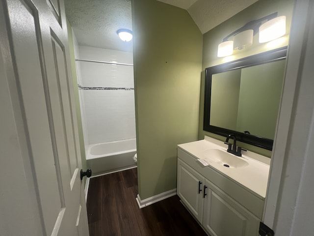 full bathroom with a textured ceiling, hardwood / wood-style floors, vanity, toilet, and shower / bathtub combination