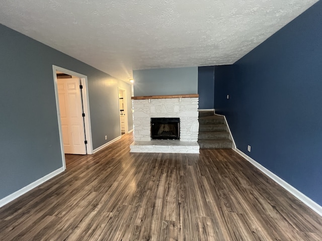 unfurnished living room featuring a textured ceiling, dark hardwood / wood-style floors, and a fireplace