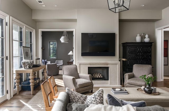 living room with light hardwood / wood-style floors and a high end fireplace