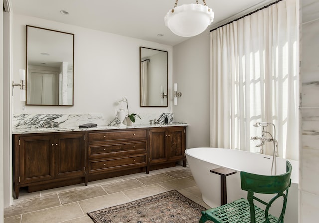 bathroom featuring a bathing tub, vanity, and tile patterned floors