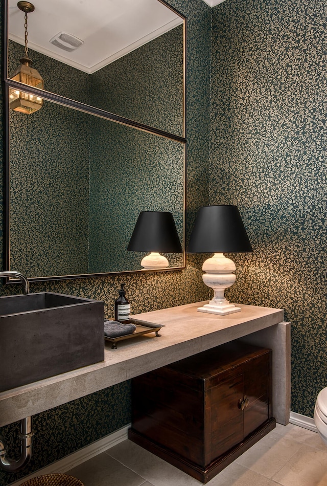 bathroom with toilet, vanity, tile patterned floors, and crown molding