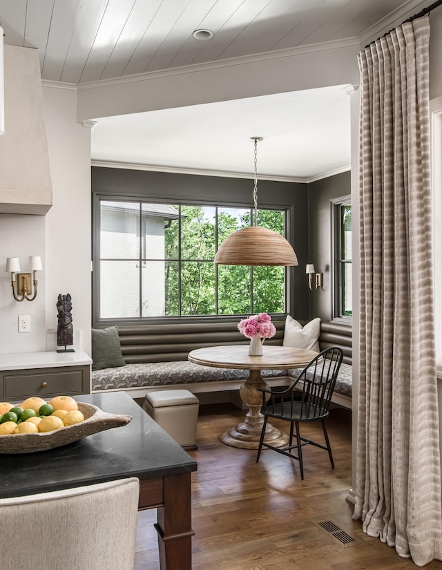 dining space featuring crown molding, breakfast area, a healthy amount of sunlight, and dark hardwood / wood-style floors