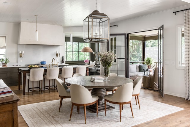 dining space with wood ceiling, hardwood / wood-style floors, a healthy amount of sunlight, and crown molding