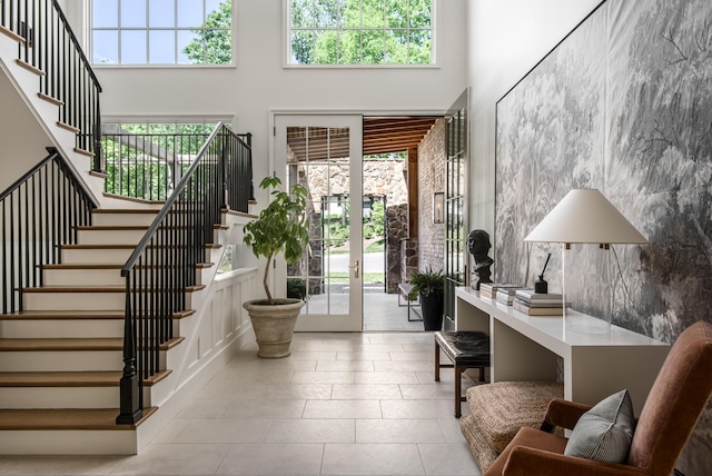 tiled entryway featuring a high ceiling, tile walls, and french doors