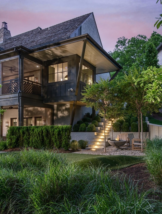 back house at dusk with a balcony