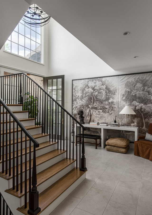 stairway featuring a notable chandelier and a high ceiling