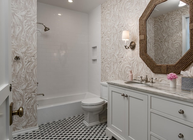 full bathroom featuring tiled shower / bath, vanity, and toilet