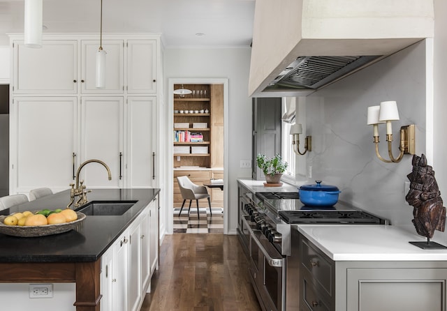 kitchen featuring dark hardwood / wood-style flooring, sink, range with two ovens, and white cabinets