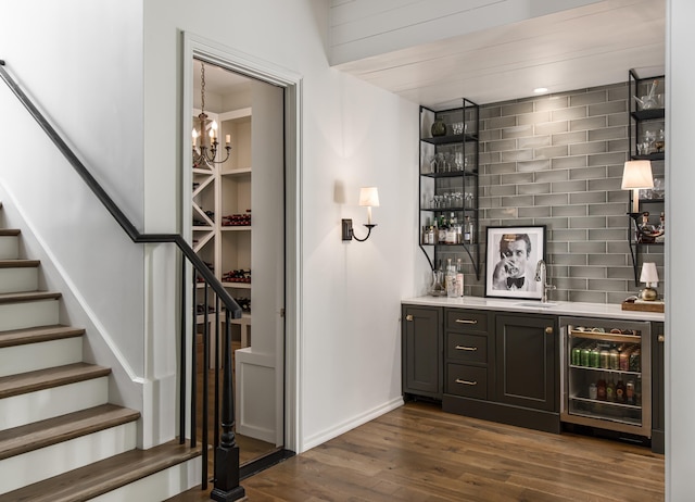 bar featuring beverage cooler, sink, dark hardwood / wood-style flooring, and tasteful backsplash