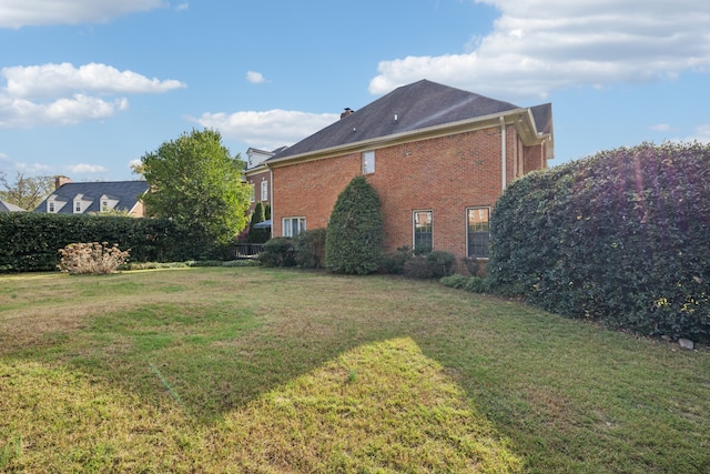 view of side of home with a yard