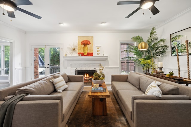 living room featuring a brick fireplace, ornamental molding, and ceiling fan