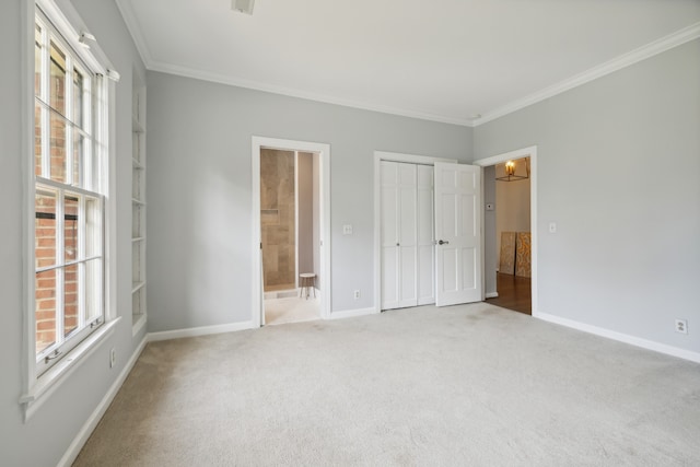 unfurnished bedroom featuring carpet floors, a closet, ornamental molding, and ensuite bath