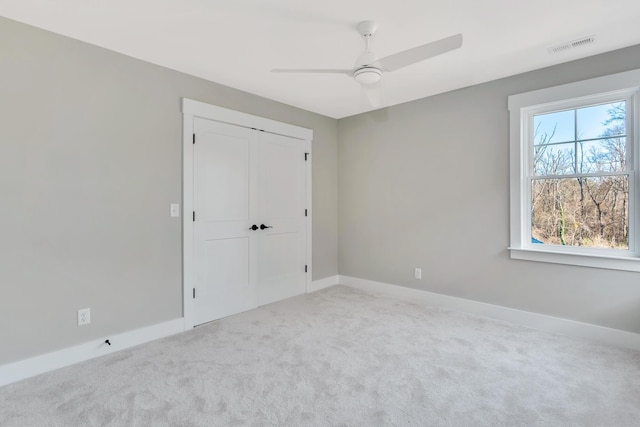 unfurnished bedroom featuring ceiling fan, carpet floors, and a closet