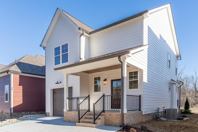 view of front facade with a garage, central AC, and a porch