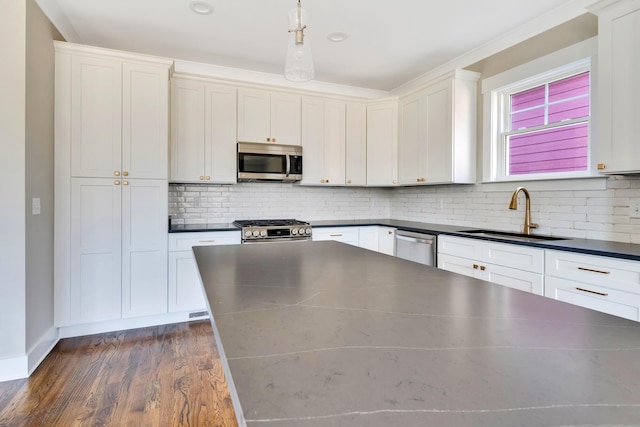 kitchen featuring white cabinetry, sink, stainless steel appliances, and hanging light fixtures