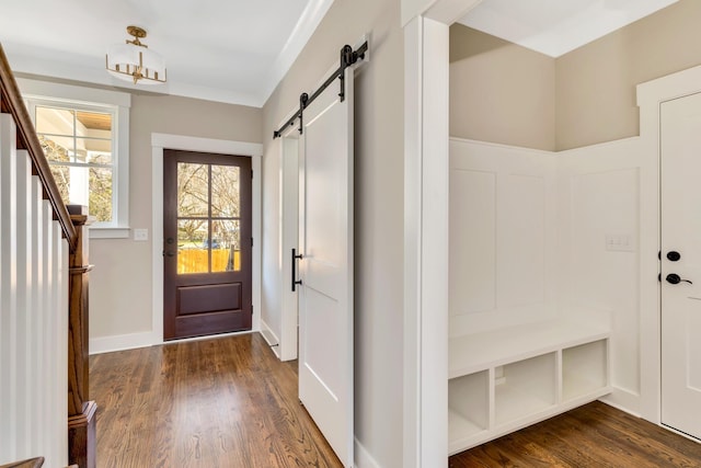 mudroom with dark wood-type flooring and a barn door