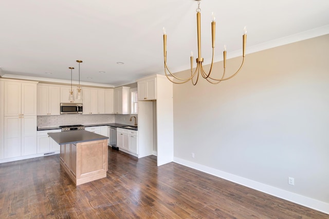 1297 Thomas Ave, Chattanooga, TN 37409 - kitchen with stainless steel appliances, dark countertops, a kitchen island, backsplash, and a chandelier