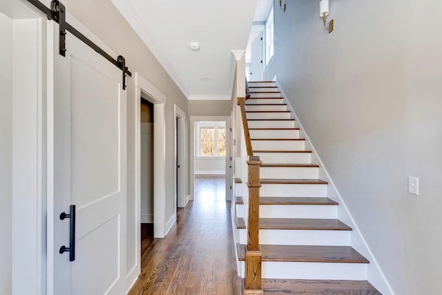 stairway featuring a barn door and hardwood / wood-style floors