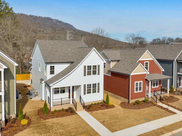 view of front of home with central AC unit, a porch, and a mountain view