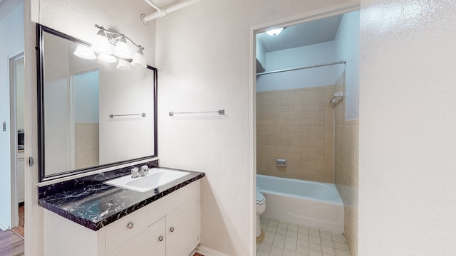 full bathroom with toilet, vanity, and tiled shower / bath