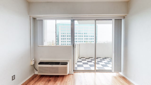 unfurnished room with a wall unit AC and hardwood / wood-style floors