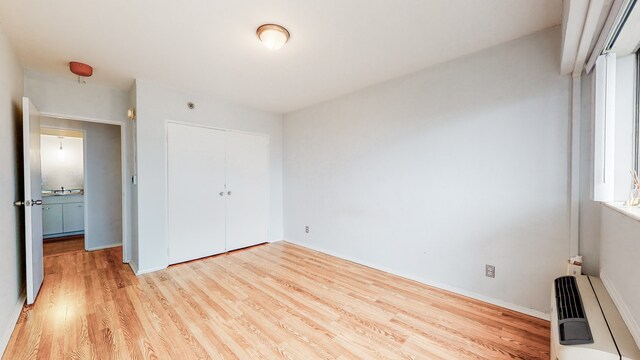 unfurnished bedroom featuring light hardwood / wood-style floors and a closet