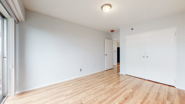 unfurnished bedroom with a closet and light wood-type flooring