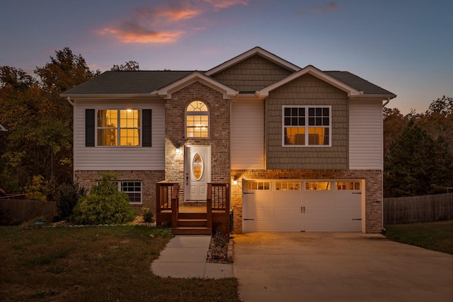 view of front of property with a garage and a yard