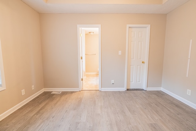 unfurnished bedroom with a textured ceiling and light hardwood / wood-style flooring