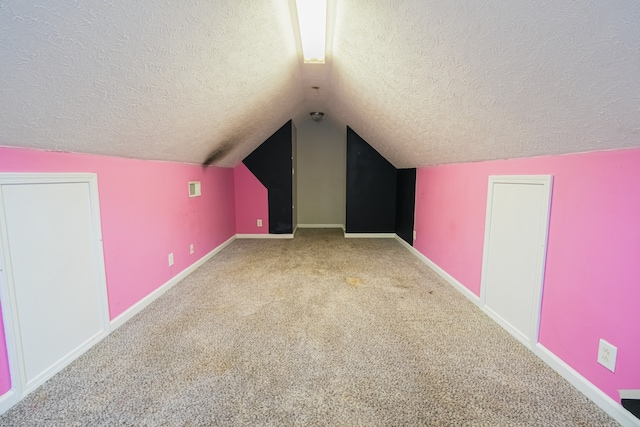 bonus room with a textured ceiling, lofted ceiling, and carpet floors