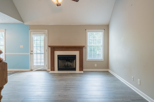 unfurnished living room featuring hardwood / wood-style floors, ceiling fan, plenty of natural light, and vaulted ceiling