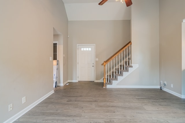 foyer entrance with hardwood / wood-style flooring, a high ceiling, and ceiling fan