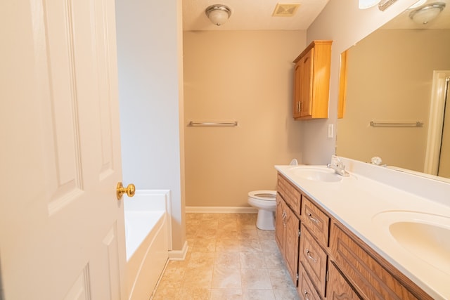 bathroom with vanity, a tub to relax in, and toilet