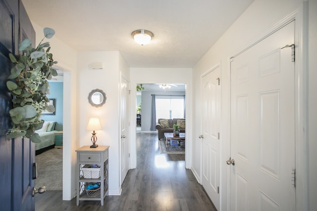 hall with dark hardwood / wood-style floors and a textured ceiling