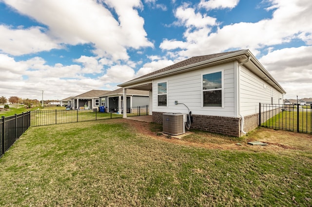 rear view of property with central AC unit, a lawn, and a patio