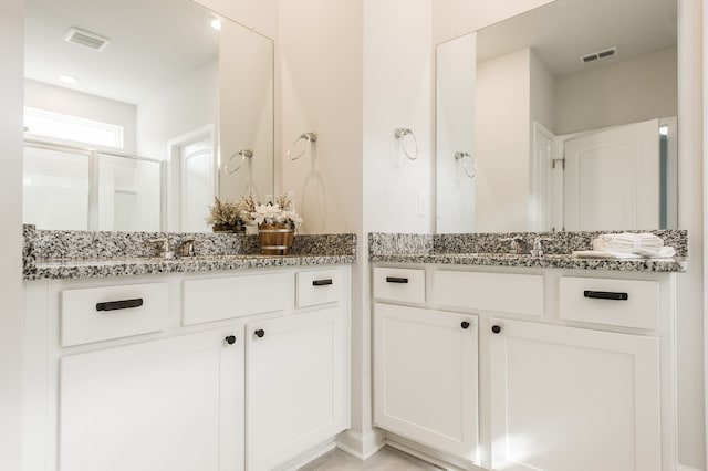 bathroom with vanity and a shower with door