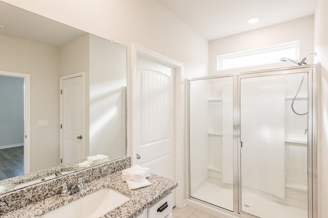 bathroom featuring hardwood / wood-style flooring, vanity, and an enclosed shower