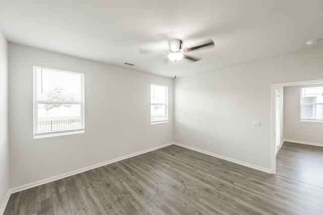 empty room with dark wood-type flooring and ceiling fan