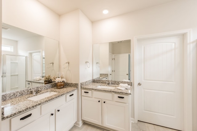 bathroom featuring vanity, tile patterned floors, and a shower with door