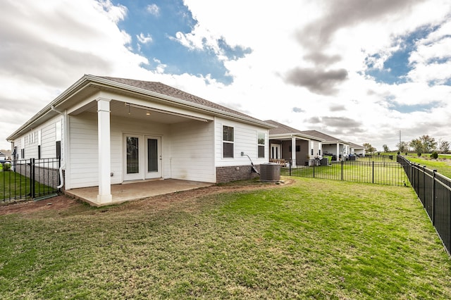 rear view of house with a lawn, central AC, and a patio