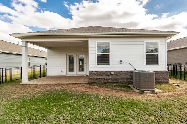 rear view of house featuring a lawn, cooling unit, and a patio area