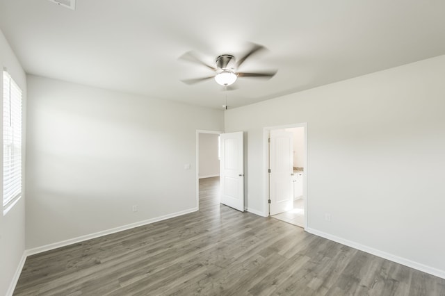 empty room featuring dark wood-type flooring and ceiling fan