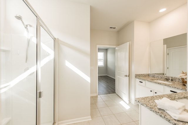 bathroom featuring vanity, a shower with door, and tile patterned floors