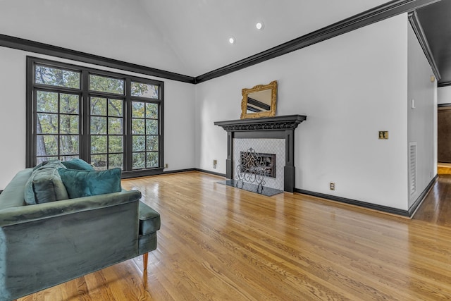 living room with a fireplace, wood-type flooring, crown molding, and vaulted ceiling