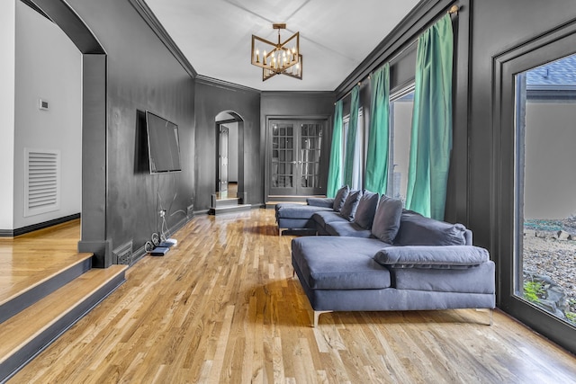 living area with a chandelier, hardwood / wood-style flooring, and ornamental molding