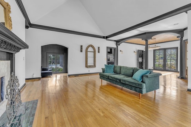 living room featuring ornamental molding, light wood-type flooring, a wealth of natural light, and ornate columns