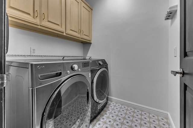 laundry room with cabinets and washing machine and clothes dryer