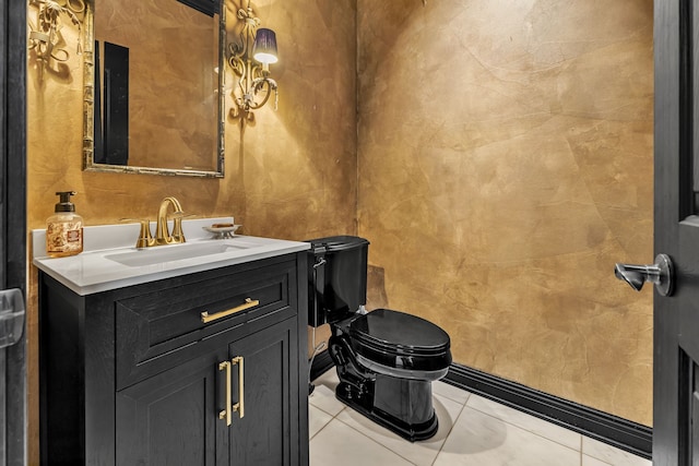 bathroom with toilet, vanity, and tile patterned flooring